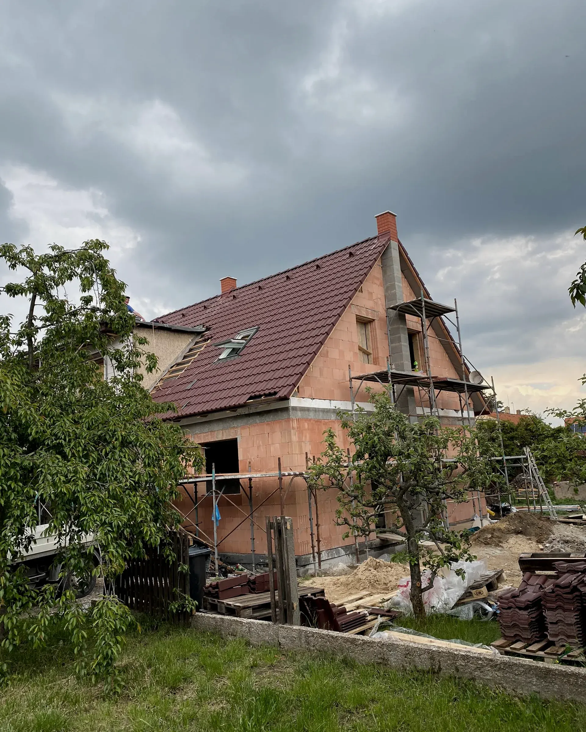 Hrubá stavba rodinného domu z cihel s novou střechou
